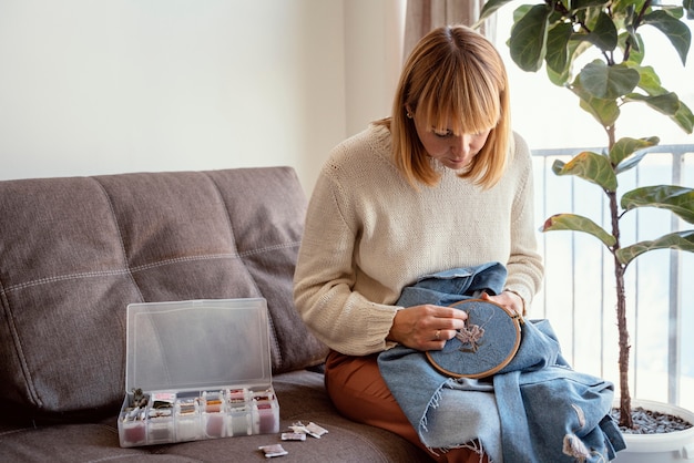 Žena vyšíva pri stole